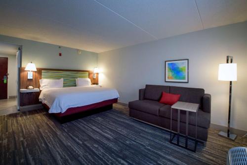 Habitación de hotel con cama y sofá en Hampton Inn Fayetteville, en Fayetteville