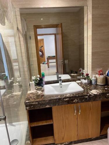a bathroom with a sink and a large mirror at Appartement de luxe à peninsula in Casablanca
