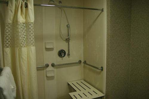 Hampton Inn Stroudsburg Poconos في سترودسبورغ: حمام مع دش مع مقعد فيه