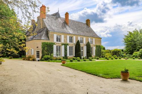 una grande casa con un vialetto davanti di Maison d'hôtes et gîte en Sarthe a Saint-Christophe-en-Champagne