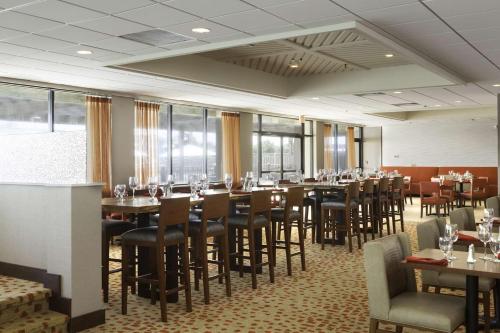 a dining room with tables and chairs and windows at DoubleTree by Hilton Atlantic Beach Oceanfront in Atlantic Beach