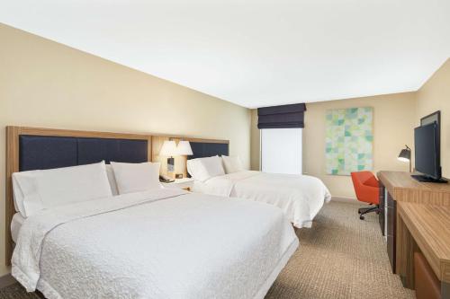 a hotel room with two beds and a flat screen tv at Hampton Inn Thomasville in Thomasville