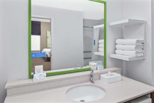 Un baño con lavabo y un espejo grande. en Hampton Inn Thomasville, en Thomasville
