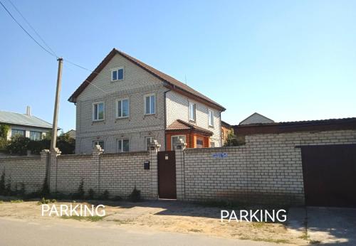 une maison avec une clôture en briques et un garage dans l'établissement Guest House in Mykolaiv, à Mykolaïv