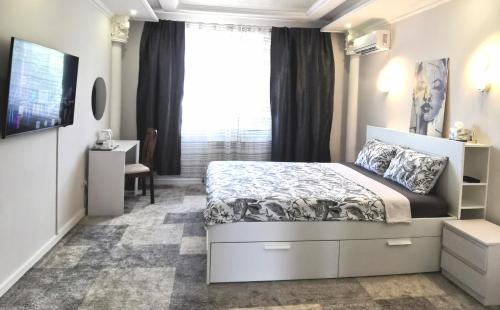 - une chambre avec un lit et une grande fenêtre dans l'établissement Guest House in Mykolaiv, à Mykolaïv