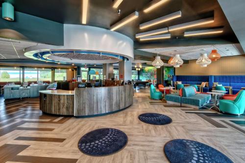a lobby of a hotel with a bar and chairs at Tru By Hilton Roanoke Hollins in Roanoke