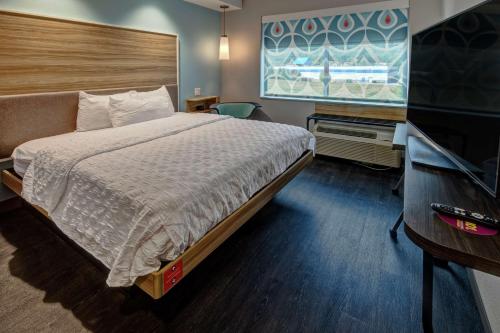 a hotel room with a bed and a flat screen tv at Tru By Hilton Roanoke Hollins in Roanoke