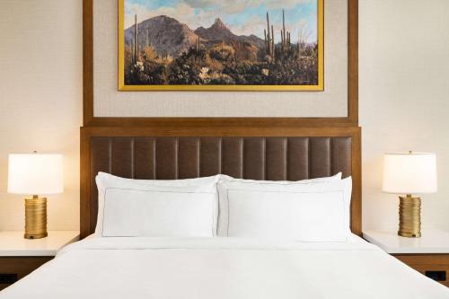 斯科茨Hilton North Scottsdale At Cavasson的一间卧室，有一张大床，配有两盏灯