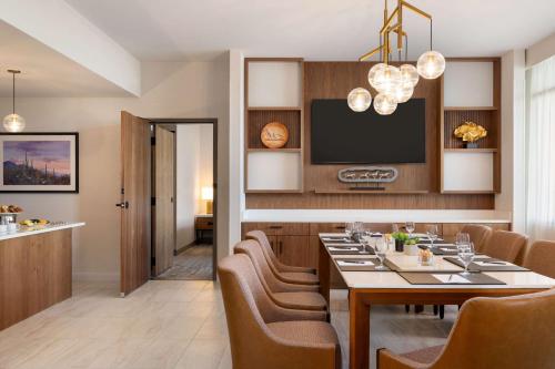 a dining room with a table and chairs and a tv at Hilton North Scottsdale At Cavasson in Scottsdale