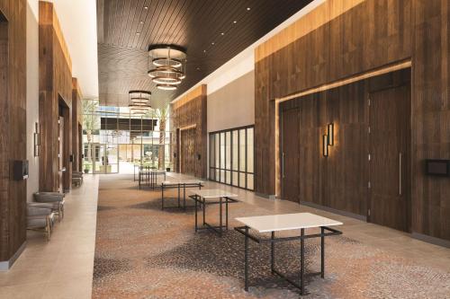 a hallway with tables and chairs in a building at Hilton North Scottsdale At Cavasson in Scottsdale