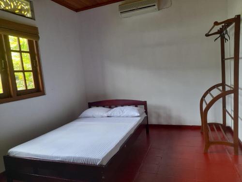 a bed in a room with a window and a chair at Colombo Home Stay - Horahena in Kaduwela