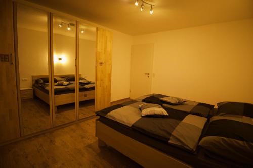 a bedroom with two beds and a mirror at Ferienwohnung Jessy in Maurach