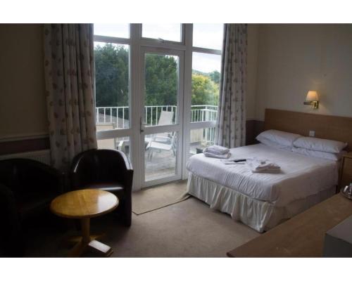 Habitación de hotel con cama y balcón en Richmond Hotel, en Torquay