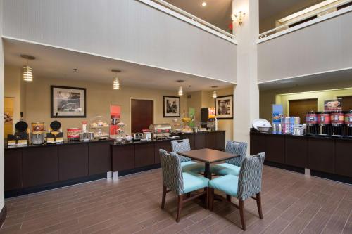 a waiting room with a table and chairs and a store at Hampton Inn Cornelia in Cornelia