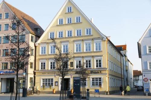 a yellow building in the middle of a street at Hotel Alte Post in Mindelheim