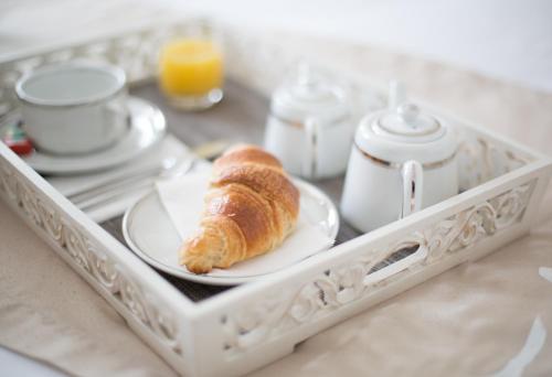 a tray with a plate with a croissant on it at Hotel Autre Mer in Noirmoutier-en-l'lle