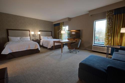 a hotel room with two beds and a desk at Hampton Inn & Suites by Hilton Tampa Busch Gardens Area in Tampa