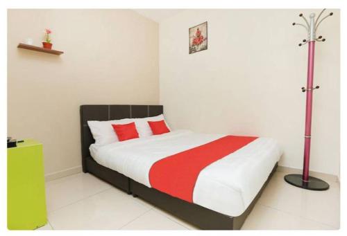 1 dormitorio con 1 cama con manta roja y blanca en Semerah Suites Homestay, en Pontian Kecil