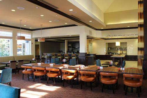 a dining room with wooden tables and chairs at Hilton Garden Inn Clovis in Clovis