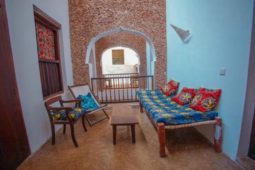 een woonkamer met een bank en 2 stoelen bij Amu House in Lamu