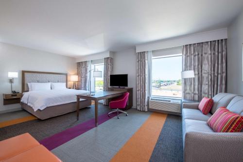 Habitación de hotel con cama, escritorio y sofá en Hampton Inn & Suites Phoenix - East Mesa in Gilbert en Gilbert