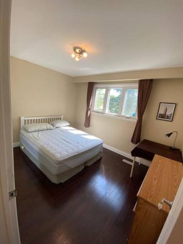 a bedroom with a bed and a desk and a window at Lovely house in a nice community in Toronto