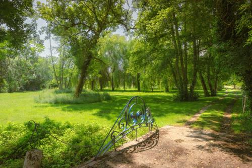 um banco de parque sentado no meio de um campo em Le Moulin de Bafave em Périssac