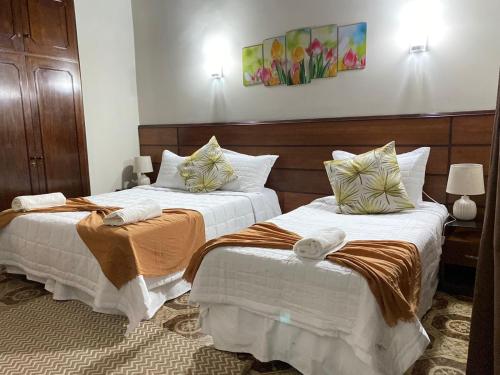 2 Betten in einem Hotelzimmer mit Handtüchern darauf in der Unterkunft Las Orquídeas Hotel Boutique in Asunción