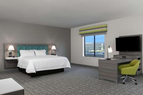 a hotel room with a bed and a flat screen tv at Hampton Inn O'Fallon, Il in O'Fallon