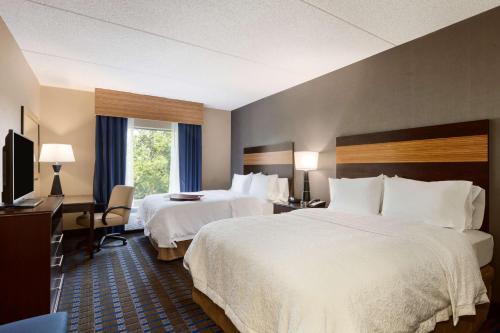 a hotel room with two beds and a television at Hampton Inn and Suites Camp Springs in Camp Springs