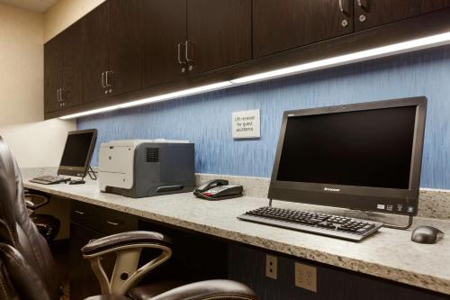a desk with a computer and a printer on a counter at Hampton Inn and Suites Camp Springs in Camp Springs