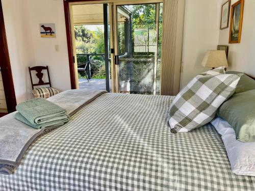 a bed with two pillows on top of it at Bello Cottage in Bellingen