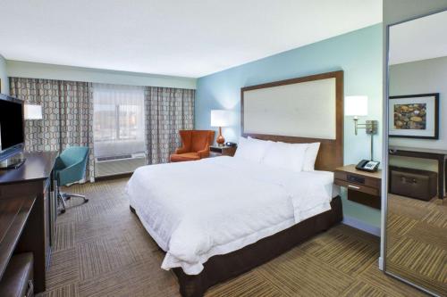 a hotel room with a large bed and a television at Hampton Inn Gaylord in Gaylord