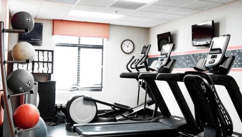 a gym with exercise bikes and a clock on the wall at Hampton Inn & Suites Richmond Glenside in Richmond
