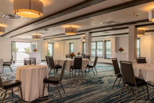 a banquet room with white tables and chairs and windows at Hotel Canandaigua, Tapestry Collection By Hilton in Canandaigua