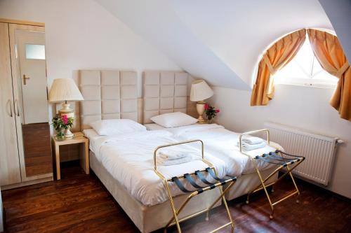 - une chambre avec un grand lit blanc et 2 chaises dans l'établissement Kuźnia Pałacowa, à Korczew