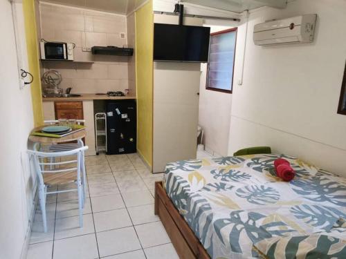 1 dormitorio con cama, mesa y cocina en Studio avec grande terrasse, en Saint-Denis