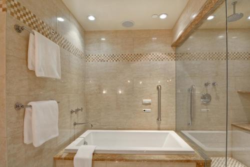 a large bathroom with a tub and a shower at The Cincinnatian Curio Collection by Hilton in Cincinnati