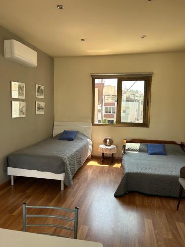 1 Schlafzimmer mit 2 Betten und einem Fenster in der Unterkunft Extremely comfy 10min walk to Beach & Town in Larnaka