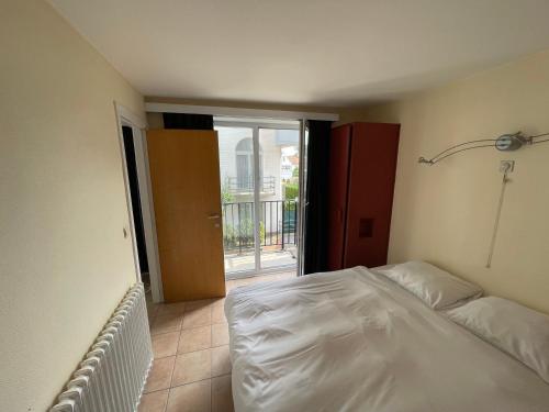 een slaapkamer met een wit bed en een balkon bij Hotel Du Soleil in Knokke-Heist