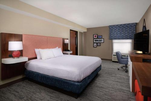 a hotel room with a bed and a television at Hampton Inn Youngstown West in Mineral Ridge