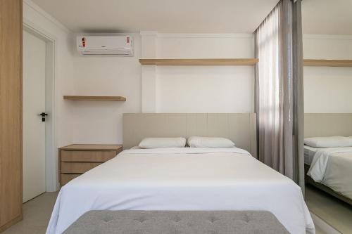 a bedroom with a large white bed and a window at Xtay Soho Florianópolis - Estúdio Completo com máquina de lavar e Wifi rápido in Florianópolis