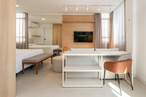 a hotel room with a bed and a table and chairs at Xtay Soho Florianópolis - Estúdio Completo com máquina de lavar e Wifi rápido in Florianópolis