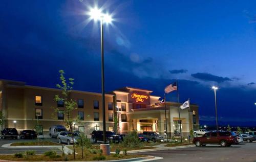 a hotel with a parking lot and a street light at Hampton Inn Sheridan in Sheridan