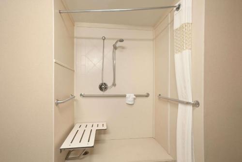 a bathroom with a bench and a shower at Hampton Inn Sheridan in Sheridan