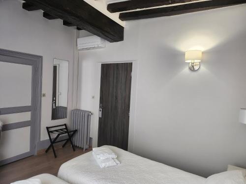 a white room with two beds and a chair at Villa Pona in Digoin