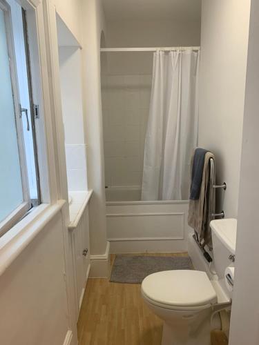 La salle de bains blanche est pourvue d'une douche et de toilettes. dans l'établissement St Martins, à Londres