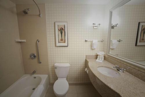a bathroom with a sink and a toilet and a tub at Hilton Garden Inn Albuquerque Uptown in Albuquerque