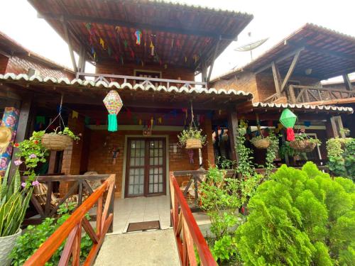 une maison avec une terrasse couverte avec des plantes devant elle dans l'établissement Casa Paraíso, à Gravatá