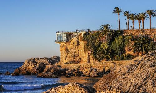 a house on top of a cliff next to the ocean at Villa Jara 25 in Nerja